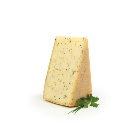 Bio-Schnittkäse mit Kräutern, elegant präsentiert neben frischer Petersilie.
